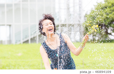 公園で水遊びするきれいなアラフィフ女性 公園で水遊びするきれいなアラフィフ女性 46894109