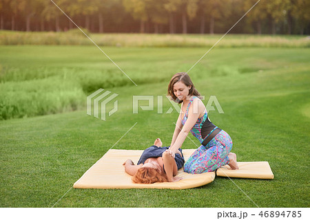 Two women perfoming thai massage. 46894785