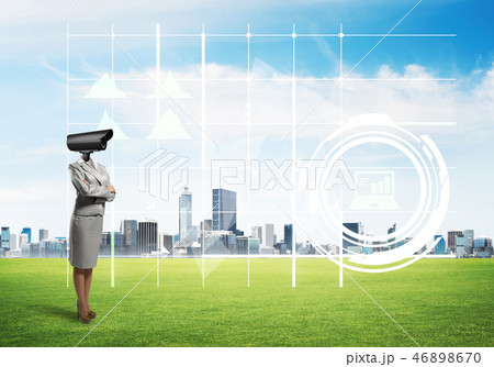 Camera headed woman standing on green grass against modern cityscape Camera headed woman standing on green grass against modern cityscape 46898670