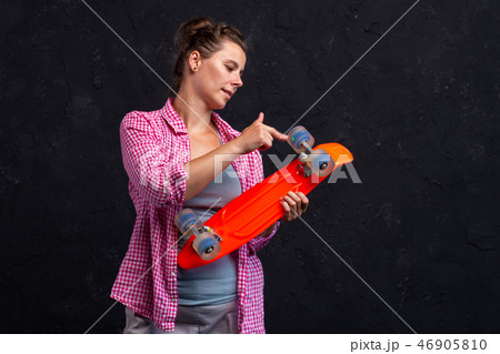 Teen girl holds skateboard. Teen girl holds skateboard. 46905810
