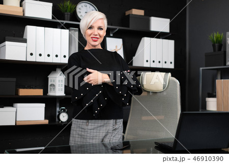 young girl stands near computer Desk in a stylish business office young girl stands near computer Desk in a stylish business office 46910390
