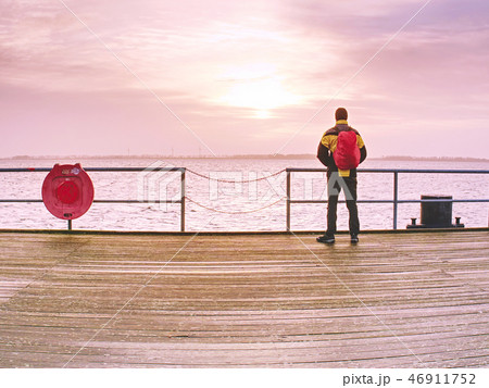 Man in trekking suit in harbor in daybreak. 46911752