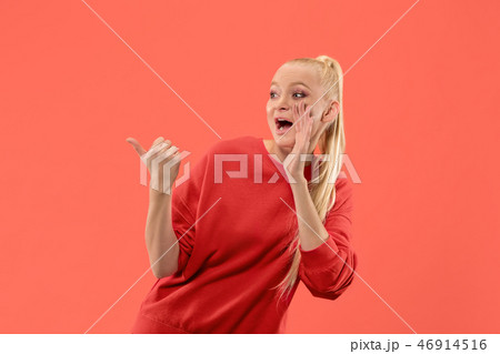 Isolated on coral young casual woman shouting at studio 46914516