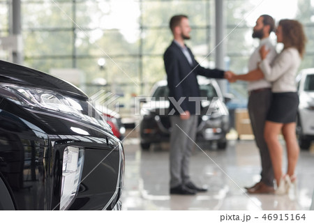 Men shaking hands, standing in car showroom. Men shaking hands, standing in car showroom. 46915164
