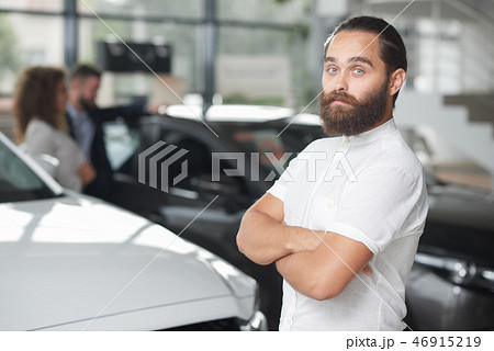 Brutal man posing in car dealership. Brutal man posing in car dealership. 46915219