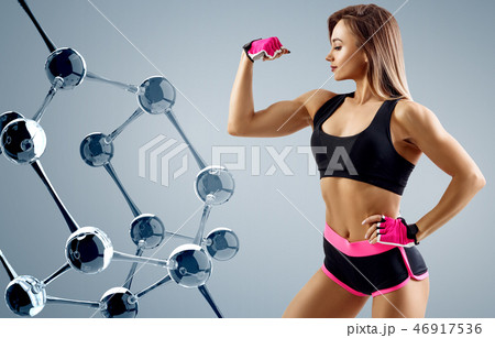 Athletic woman standing near glass molecule chain. 46917536