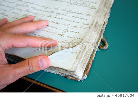 man showing very old book pages 46917604