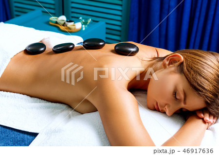 Thai therapist doing massage with hot stones. 46917636
