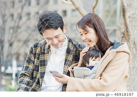 スマホを見る夫婦 休日の公園 スマホを見る夫婦 休日の公園 46918197