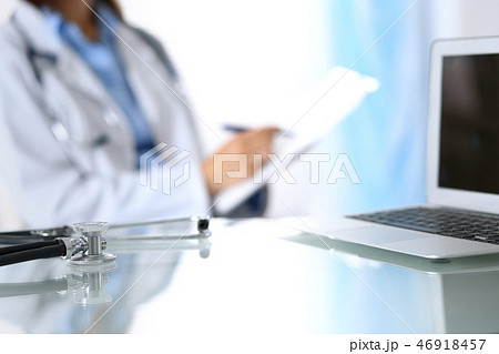 Stethoscope lying on glass desk with laptop computer at busy physician background. Medicine or Stethoscope lying on glass desk with laptop computer at busy physician background. Medicine or 46918457