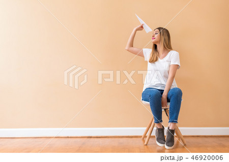 Young woman with a paper airplane Young woman with a paper airplane 46920006