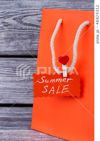 Orange shopping bag with white handles. 46924352