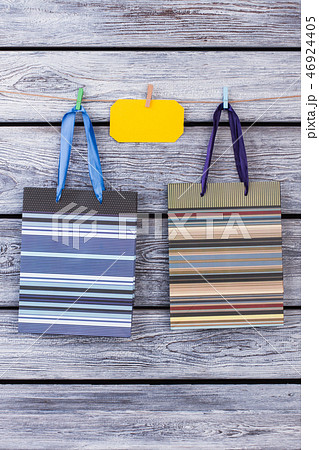 Two gift bags with stripes on wooden background. 46924405