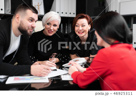 Smiling employees talking in workplace Smiling employees talking in workplace 46925311