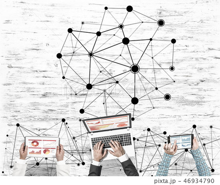 Top view of businesspeople sitting at table and using gadgets Top view of businesspeople sitting at table and using gadgets 46934790