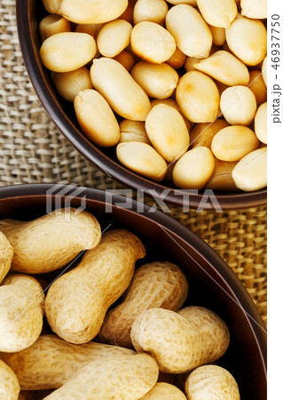 Peanuts in the shell and peeled close-up in cups. Peanuts in the shell and peeled close-up in cups. 46937750