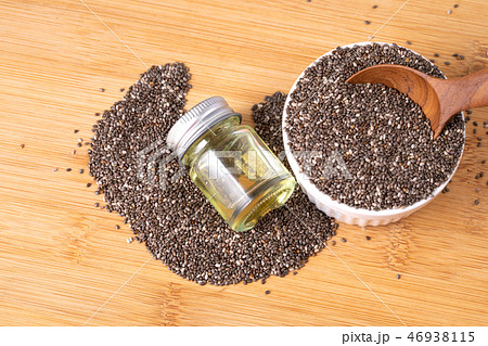 Chia essential oil and seeds in wooden spoon Chia essential oil and seeds in wooden spoon 46938115