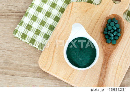 spirulina powder in bowl and spirulina pills 46938254