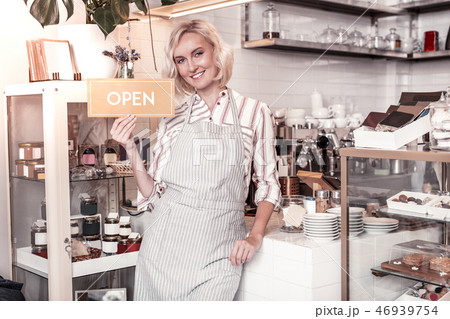Joyful positive young woman opening her cafe 46939754