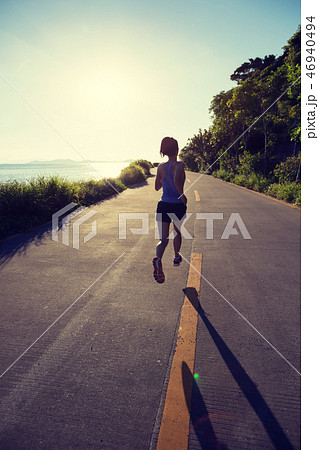 woman running on seaside trail in the morning woman running on seaside trail in the morning 46940494