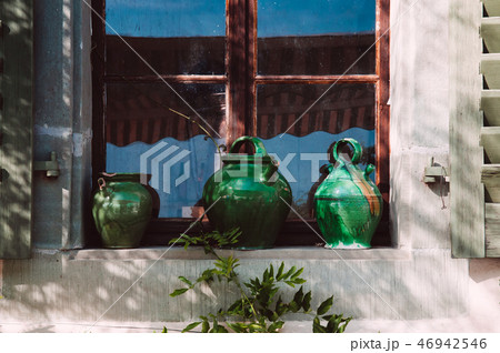 Old green ceramic pottery at old wooden window 46942546