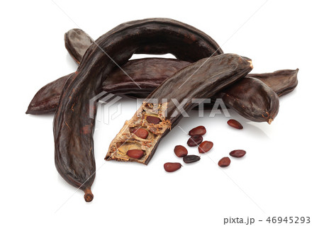 Ripe carob pods and seeds on white background 46945293
