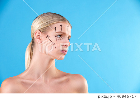 Beautiful Woman Face. Beauty Portrait of young woman blond, painted lines on the face for cosmetic Beautiful Woman Face. Beauty Portrait of young woman blond, painted lines on the face for cosmetic 46946717