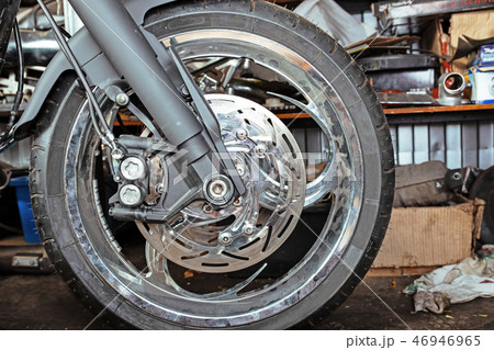Cropped close up shot of beautiful and custom made motorcycle in the workshop Cropped close up shot of beautiful and custom made motorcycle in the workshop 46946965