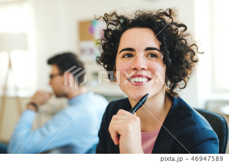 A portrait of young businesswoman with colleagues in a modern office. 46947589
