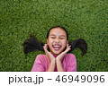 kid asian girl's lie leisurely on the Lawn floor 46949096