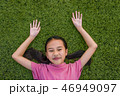 kid asian girl's lie leisurely on the Lawn floor 46949097