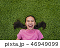 kid asian girl's lie leisurely on the Lawn floor 46949099