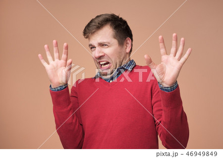 Handsome man demonstrates refusal gesture Handsome man demonstrates refusal gesture 46949849
