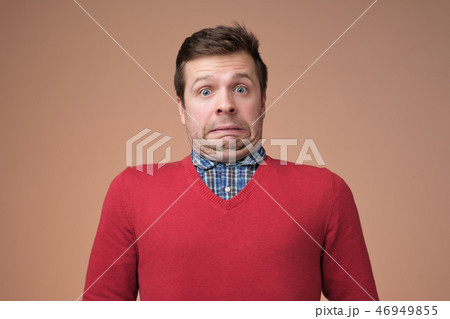 man grimacing guilty face at studio background man grimacing guilty face at studio background 46949855