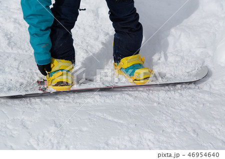スノーボードのバインディングをつける女性 スノーボードのバインディングをつける女性 46954640