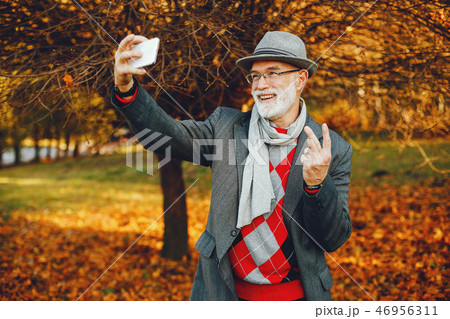 Elegant old man in a sunny autumn park  46956311