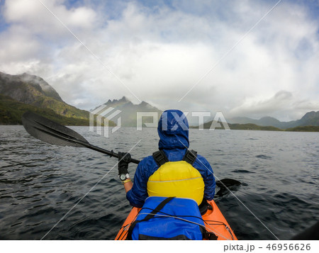 Photo from back of tourist with paddle on canoe floating Photo from back of tourist with paddle on canoe floating 46956626