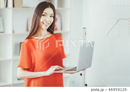 Joyful young woman holding her laptop Joyful young woman holding her laptop 46959120