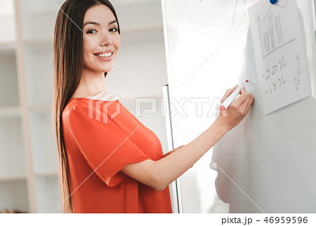 Appealing stylish businesswoman holding red marker in her hand Appealing stylish businesswoman holding red marker in her hand 46959596