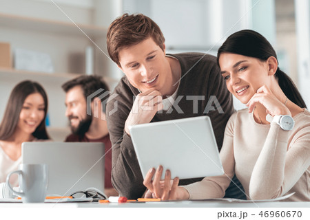 Smart positive colleagues looking at the tablet screen 46960670