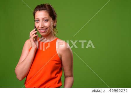 Beautiful businesswoman against green background 46966272