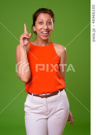 Beautiful businesswoman against green background 46966280