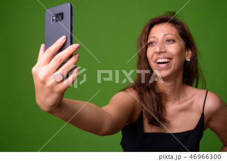 Beautiful woman against green background 46966300