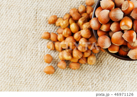 Peeled hazelnuts in a wooden, dark brown cup on Peeled hazelnuts in a wooden, dark brown cup on 46971126