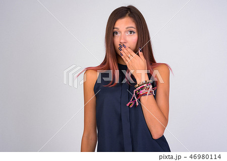 Portrait of young guilty businesswoman covering mouth Portrait of young guilty businesswoman covering mouth 46980114