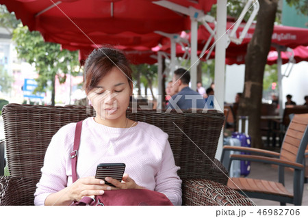 カフェでスマートホンを使う女性 カフェでスマートホンを使う女性 46982706