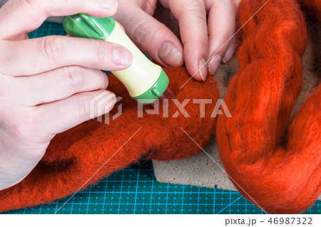 craftsman poking felt with felting punch close up craftsman poking felt with felting punch close up 46987322
