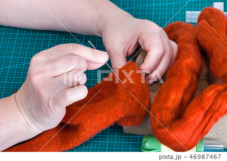 craftsman fixes fibers in felt with felting needle craftsman fixes fibers in felt with felting needle 46987467