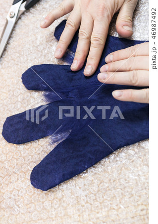 craftsman puts fibers on fingers of wet glove 46987492