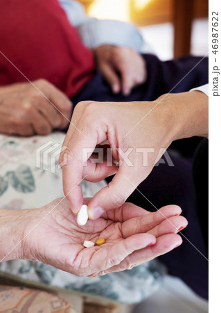 doctor giving some pills to a senior woman 46987622
